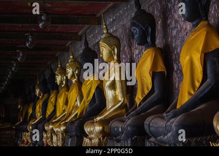 Bouddha d'or à côté de vieux murs dans les temples thaïlandais Banque D'Images