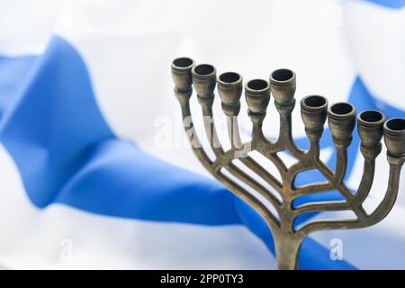 Bonne Hanoukkah. Hanoukkah vieille Menorah sur fond de drapeau israélien avec lumière du soleil ou bokeh sur fond de bois blanc. Image religieuse de jewis Banque D'Images