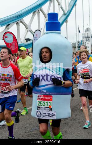 Coureur en costume de bouteille d'eau minérale naturelle de Buxton en compétition au marathon de Londres Virgin Money 2015 traversant Tower Bridge, Royaume-Uni. Banque D'Images