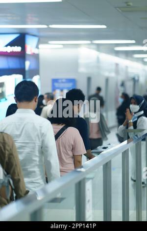 Une femme sympathique saluant les passagers à la porte d'entrée de la station MRT, Jakarta. Indonésie. 20 avril 2023. Banque D'Images