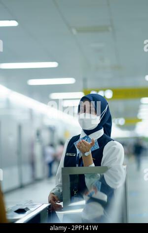 Une femme sympathique saluant les passagers à la porte d'entrée de la station MRT, Jakarta. Indonésie. 20 avril 2023. Photographie de service public. Banque D'Images