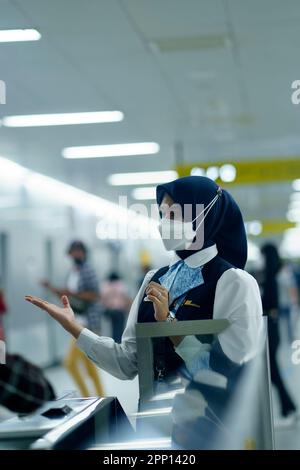 Une femme sympathique saluant les passagers à la porte d'entrée de la station MRT, Jakarta. Indonésie. 20 avril 2023. Photographie de service public. Banque D'Images