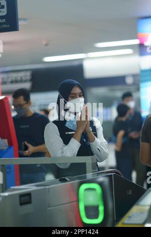 Une femme sympathique saluant les passagers à la porte d'entrée de la station MRT, Jakarta. Indonésie. 20 avril 2023. Photographie de service public. Banque D'Images