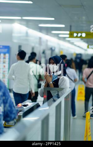 Une femme sympathique saluant les passagers à la porte d'entrée de la station MRT, Jakarta. Indonésie. 20 avril 2023. Photographie de service public. Banque D'Images