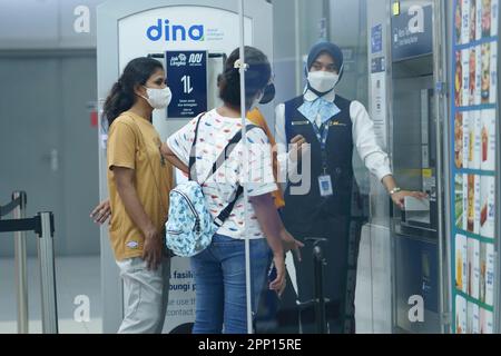 Un officier aide les gens à la machine à billets de la station MRT, Jakarta, Indonésie. 20 avril 2023. Photographie de service de publicité. Banque D'Images