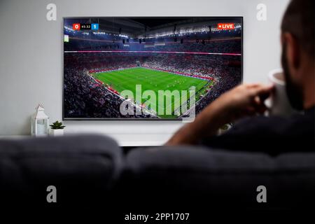 Homme regardant un match de football sur Smart TV. Transmission de football en direct. ROSARIO, ARGENTINE - 18 DÉCEMBRE 2022. Banque D'Images