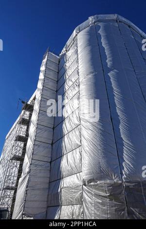 Bâtiment de maison, construction, restauration ou site d'entretien avec échafaudage et revêtement de protection en toile grise Banque D'Images