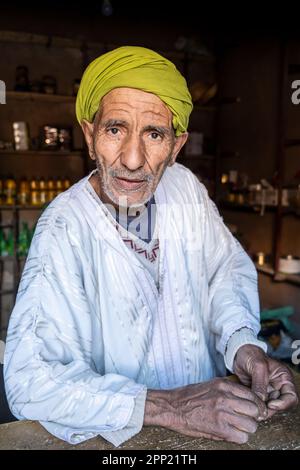 Portrait de berber homme vêtu de vêtements berbères traditionnels dans sa petite boutique. Banque D'Images