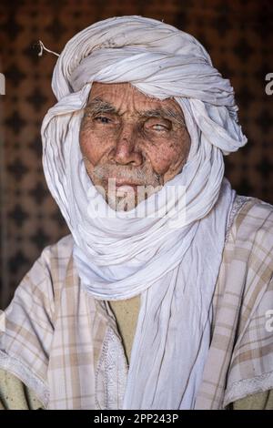 Portrait d'un aîné berbère à l'intérieur d'une tente dans son camp nomade d'Erg Chegaga. Banque D'Images