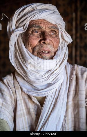 Portrait d'un aîné berbère à l'intérieur d'une tente dans son camp nomade d'Erg Chegaga. Banque D'Images