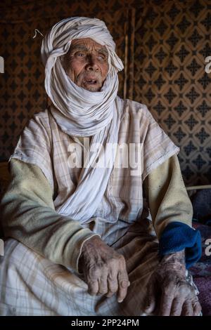 Portrait d'un aîné berbère à l'intérieur d'une tente dans son camp nomade d'Erg Chegaga. Banque D'Images