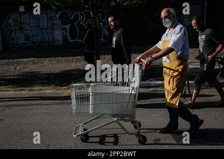 21 avril 2023, Brésil, São Paulo: Julio Lancellotti (M), prêtre, marche avec un chariot à un point de distribution alimentaire. Lancellotti est connu dans le pays sud-américain pour son travail en faveur des droits de l'homme et des classes les plus pauvres. Grâce à des dons, il fournit aux gens de la nourriture, des vêtements et des livres. Il s'oppose également à ce qu'il appelle l'hostilité contre les pauvres. Photo : Allison Sales/dpa Banque D'Images