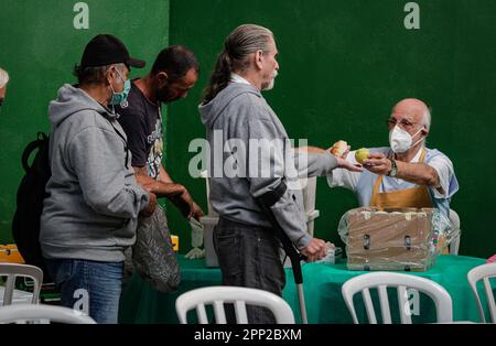 21 avril 2023, Brésil, São Paulo: Julio Lancellotti (r), prêtre, distribue de la nourriture aux gens. Lancellotti est connu dans le pays sud-américain pour son travail en faveur des droits de l'homme et des classes les plus pauvres. Grâce à des dons, il fournit aux gens de la nourriture, des vêtements et des livres. Il s'oppose également à ce qu'il appelle « l'hostilité envers les pauvres ». Photo : Allison Sales/dpa Banque D'Images