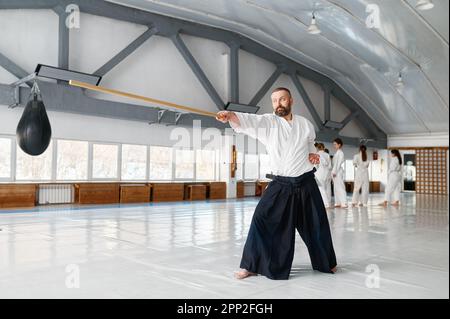 Maître Kendo pratiquant avec une épée en bois pendant la pause sur l'entraînement Banque D'Images