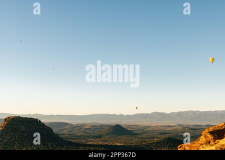 Quatre ballons d'air chaud dans le ciel flottant après un décollage tôt le matin à Sedona en Arizona. Banque D'Images