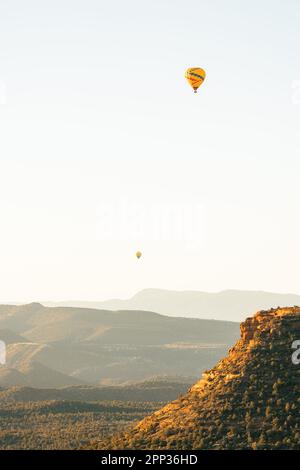 Deux ballons à air chaud, hauts et bas, prennent l'avion tôt le matin à Sedona, en Arizona. Banque D'Images