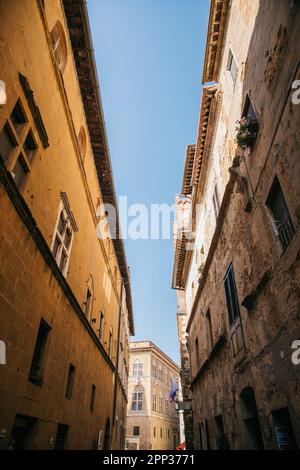 Promenade le long des rues de Pienza, en Italie, par une journée ensoleillée et claire, et vue sur les magnifiques bâtiments historiques en pierre Banque D'Images