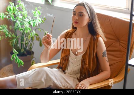 Jeune femme avec un espace de nettoyage de l'encens à la maison Banque D'Images