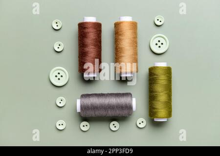 Composition avec bobines de filetage et boutons sur fond gris Banque D'Images