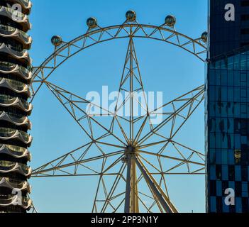 Melbourne Star observation Deck Wheel in Morning Sun entre deux immeubles de grande hauteur Banque D'Images