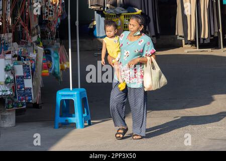 SAMUT PRAKAN, THAÏLANDE, FÉVRIER 07 2023, une femme âgée porte un petit enfant dans une rue avec une place de marché Banque D'Images