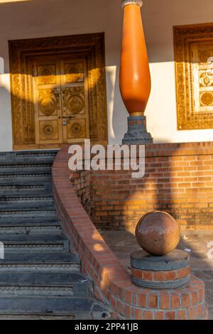 Escalier principal extérieur avec escaliers en pierre et rails en bois naturel. Une grande boule sphérique en bois forme le bord des rails dans un Tamil traditionnel, Keral Banque D'Images