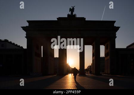 Berlin, Allemagne. 22nd avril 2023. La porte de Brandebourg projette des ombres dans le contre-jour du soleil levant. Credit: Paul Zinken/dpa/Alay Live News Banque D'Images