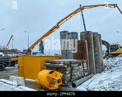 construction d'un nouveau pont dans le centre-ville. la grue de levage jaune déplace les structures en béton lourd pour créer un nouveau passage. Banque D'Images