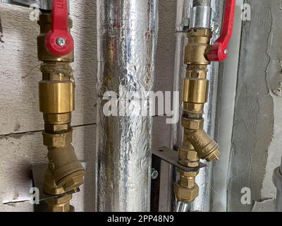 Nouveaux tuyaux d'eau et d'égout en plastique et polypropylène et en plastique et polypropylène dans l'isolation thermique avec vannes d'arrêt et d'arrêt et de contrôle pour Banque D'Images