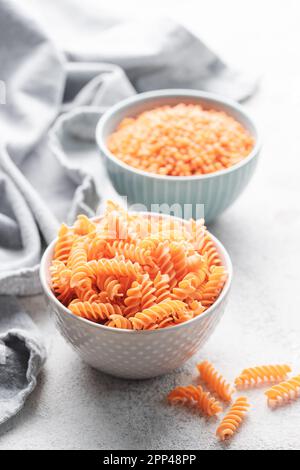 Pâtes de lentilles rouges fusilli. Bol avec pâtes crues et lentilles rouges. Pâtes sans gluten. Banque D'Images