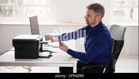 Homme d'affaires donnant la commande d'impression sur Smart Phone au bureau Banque D'Images