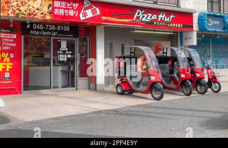 Une photo de côté de quatre motos de livraison à 3 roues de Pizza Hut avec toits et une boîte de rangement à l'arrière avec des photos du logo rouge de Pizza Hut Banque D'Images