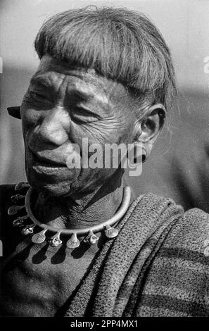 Un homme de la tribu Konyak Naga, avec des fiches déformant ses oreilles et un collier indiquant le nombre de têtes qu'il a coupées. Banque D'Images