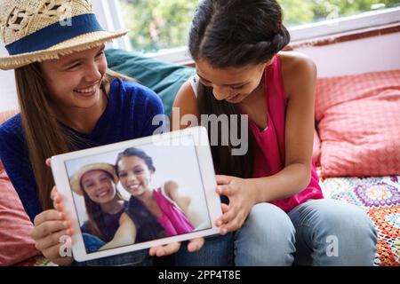 Des souvenirs qui dureront éternellement. des amis adolescents qui prennent un selfie ensemble sur une tablette numérique. Banque D'Images