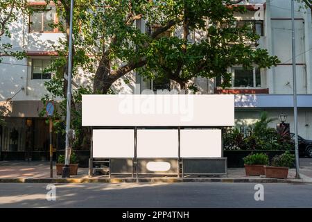 Maquette blanche vierge d'un panneau d'affichage d'arrêt de bus devant un arrière-plan de rue vide Banque D'Images