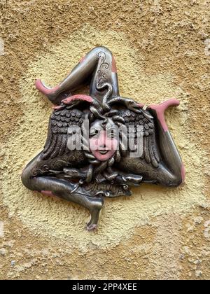 Sculpture traditionnelle en céramique de Trinacria, un symbole à trois pattes de la Sicile. Gros plan sur un mur beige. Banque D'Images