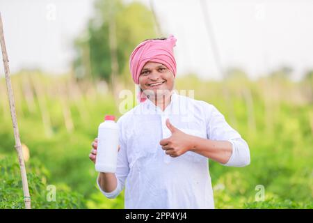 Jeune agriculteur indien montrant Smart phone, agriculteur parlant au téléphone dans la ferme, heureux agriculteur indien Banque D'Images