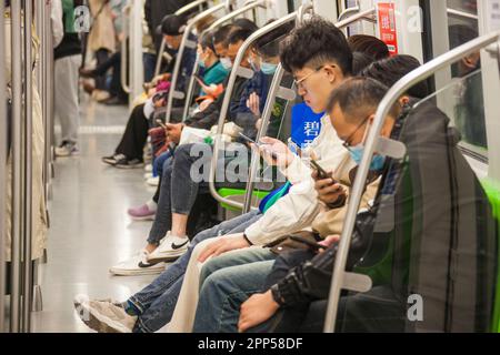 NANJING, CHINE - le 22 AVRIL 2023 - les passagers lisent leur téléphone mobile dans une voiture de métro à Nanjing, dans la province du Jiangsu, en Chine orientale, à 22 avril, en 202 Banque D'Images