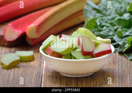 Rhubarbe fraîche dans un bol blanc sur la table Banque D'Images