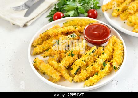 Bâtonnets de courgettes frits croustillants et sauce tomate sur l'assiette Banque D'Images