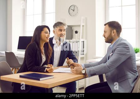 Homme et femme en discussion avec un agent immobilier, un directeur de banque ou un conseiller juridique Banque D'Images