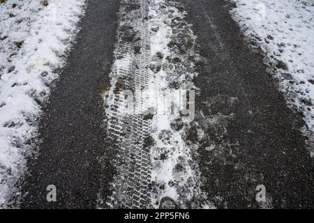 Des traces de pneus sur une route enneigée Banque D'Images