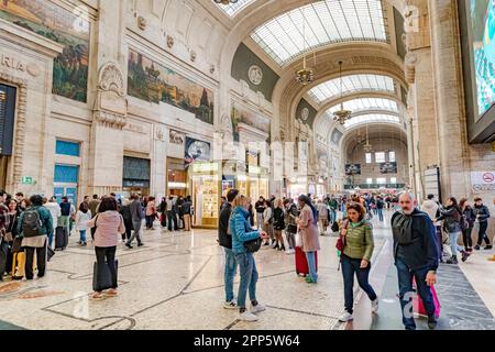 Personnes marchant à travers l'intérieur magnifique du hall d'entrée au rez-de-chaussée de la gare centrale de Milan, en Italie Banque D'Images