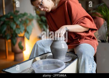 Immersion dans le processus femme façonnant pichet d'argile naturelle travaillant comme artisan dans la céramique magasin de poterie Banque D'Images