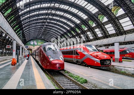 Un train à grande vitesse italien à côté d'un Trenitalia ETR 700 sous le toit voûté à la gare centrale de Milan, Milan, Italie Banque D'Images