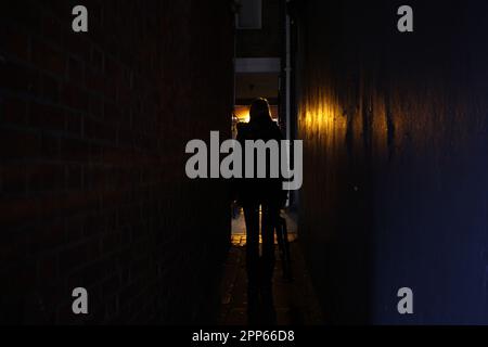 Femme dans une allée sombre la nuit Banque D'Images