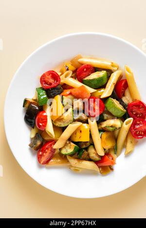 Salade de pâtes Ratatouille sur une assiette sur fond clair.Vue de dessus, plan d'appartement Banque D'Images