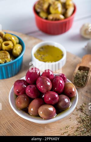 Olives kalamata rouges sur fond de bois. Olives rouges et vertes kalamata. Banque D'Images