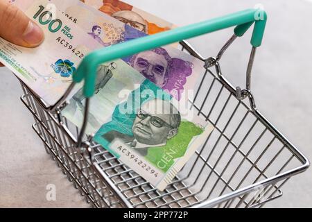 Concept, inflation en Colombie, hausse des prix dans les magasins, chariot vide et argent colombien mis dans le chariot Banque D'Images