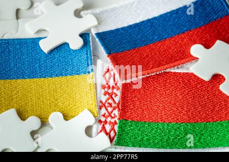 Le drapeau de la Biélorussie et le fond des drapeaux de la Russie et de l'Ukraine parmi les puzzles, le concept de la situation politique, le rôle o Banque D'Images